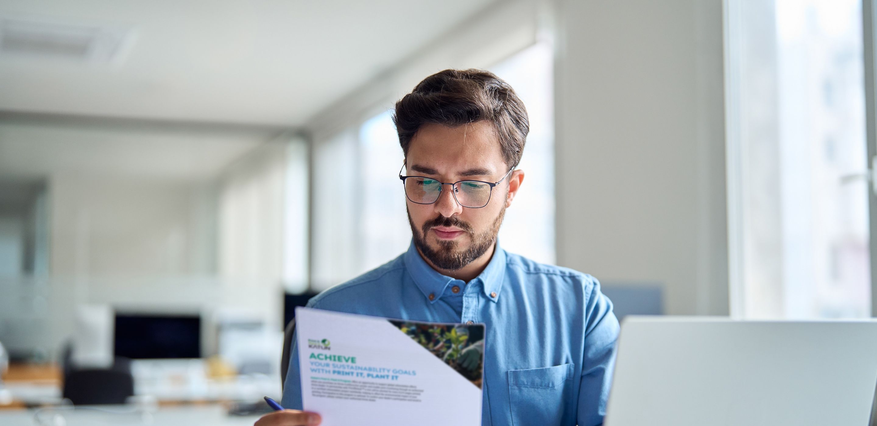 Person reviewing Katun's sustainability efforts flyer