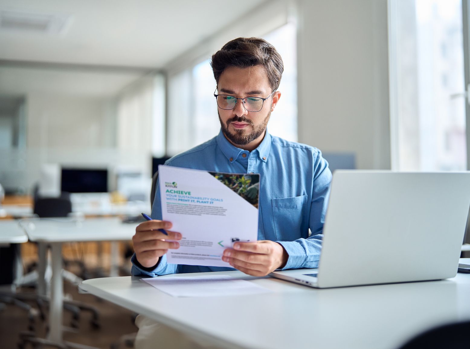 Person reviewing Katun's sustainability efforts flyer